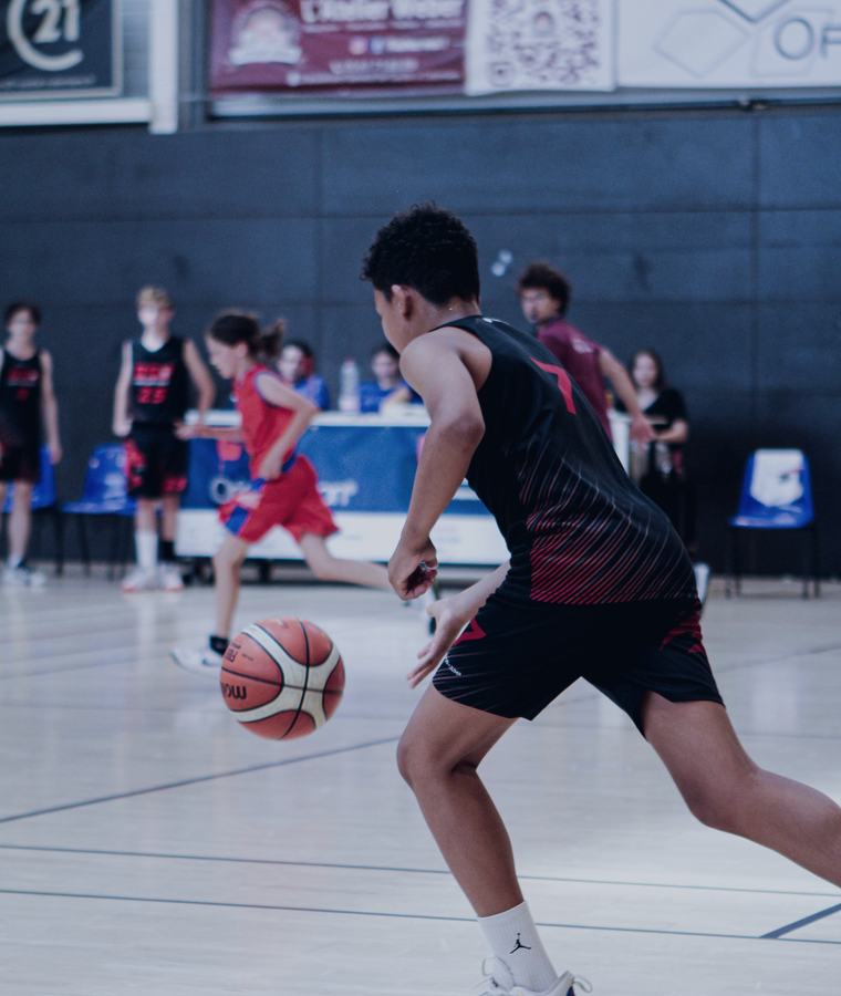 Jugador de básquetbol conduciendo el balón durante un partido formativo